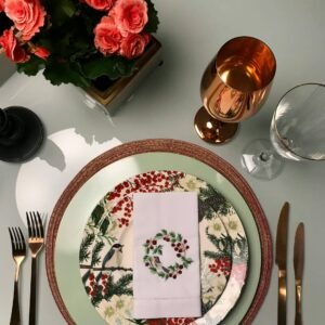 A luxurious floral table setting with copper cutlery and wine glass, perfect for fine dining.